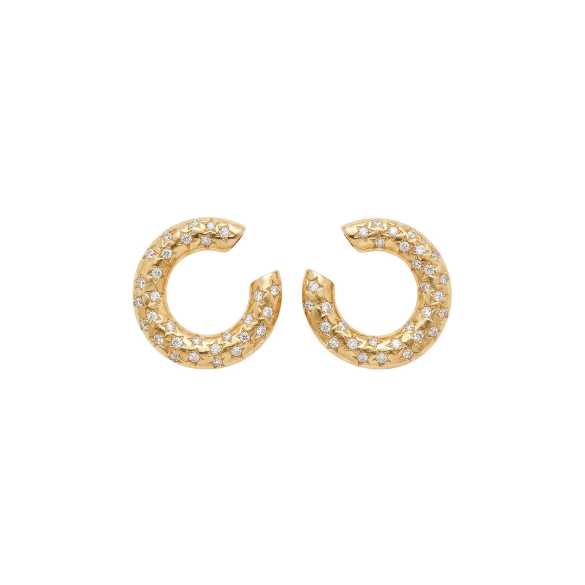 A pair of Gold and Diamond Earclips from the 1980s, crafted in 18K yellow gold with clear, sparkling diamonds, displayed symmetrically on a white background.