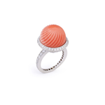 A Cartier Carved Coral and Diamond Ring from the 1950s, showcasing a large ridged coral cabochon dome at its center, surrounded by a band of sparkling pavé diamonds.