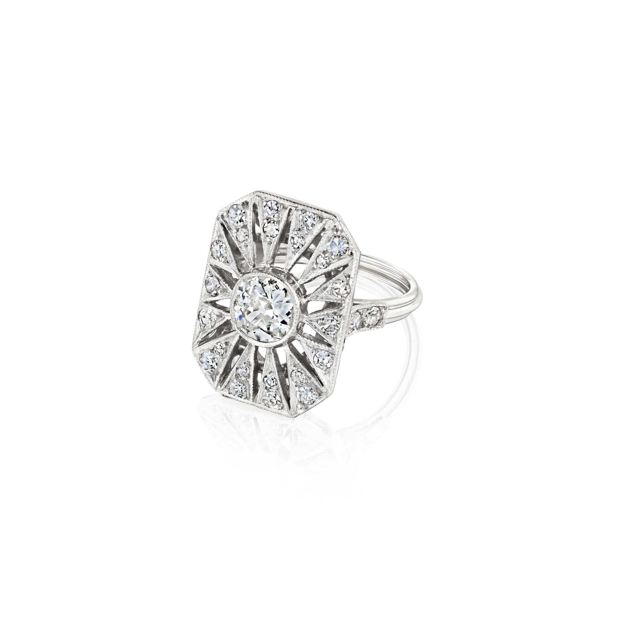 The Art Deco Diamond Ring is a platinum piece with a large old European-cut diamond at its center, set in an octagonal geometric design accented by radiating lines and smaller diamonds, shown against a white background.