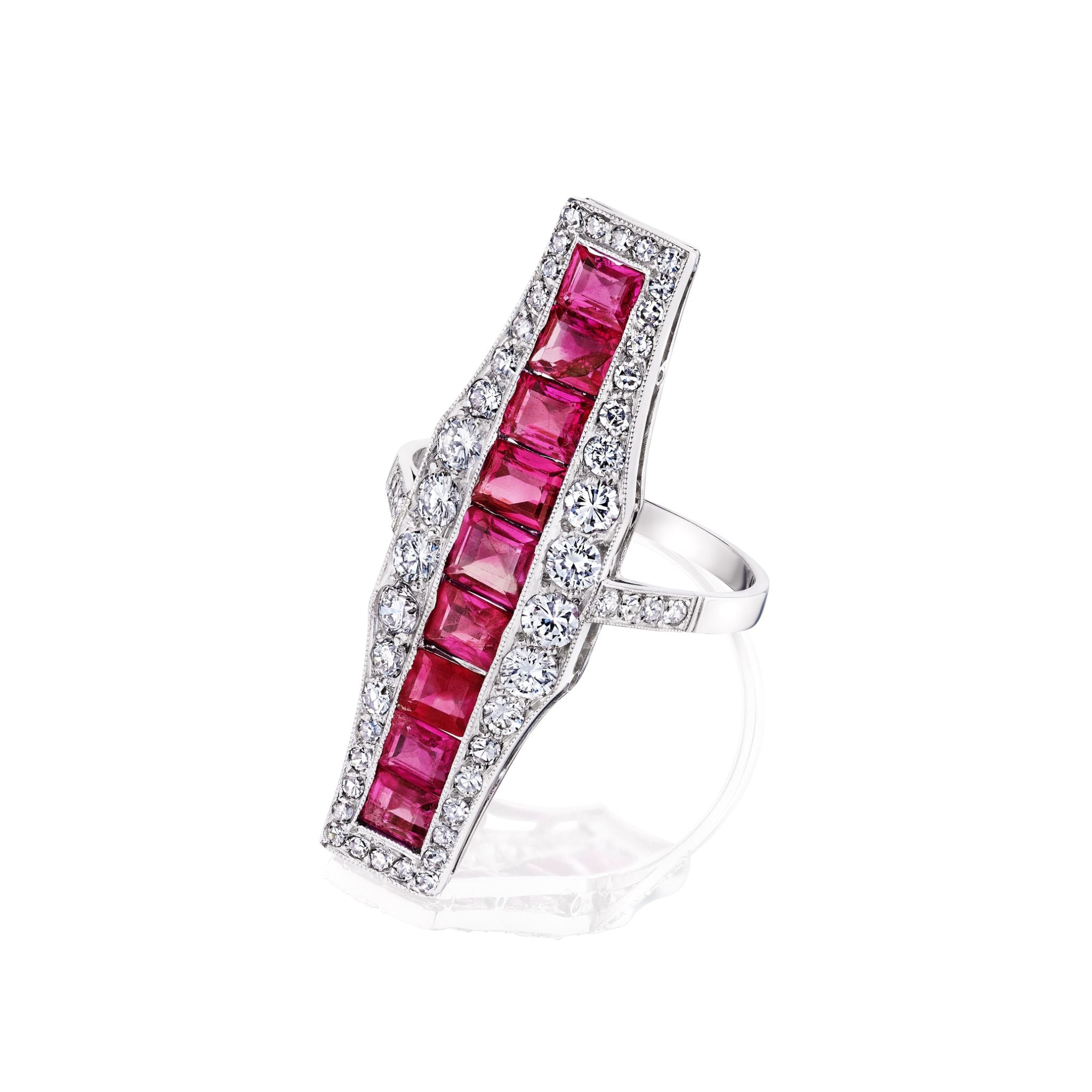 The Ruby and Diamond Ring is a 1920s platinum silver piece with a long rectangular design, showcasing a central row of calibré-cut rubies bordered by sparkling white diamonds along the edges.