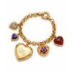 The Gold, Colored Stone and Diamond Charm Bracelet in 18K yellow gold features five puffy heart charms: a pavé diamond heart, a blue stone heart, an engraved gold heart, a red flower with blue center, and a vibrant red stone heart.