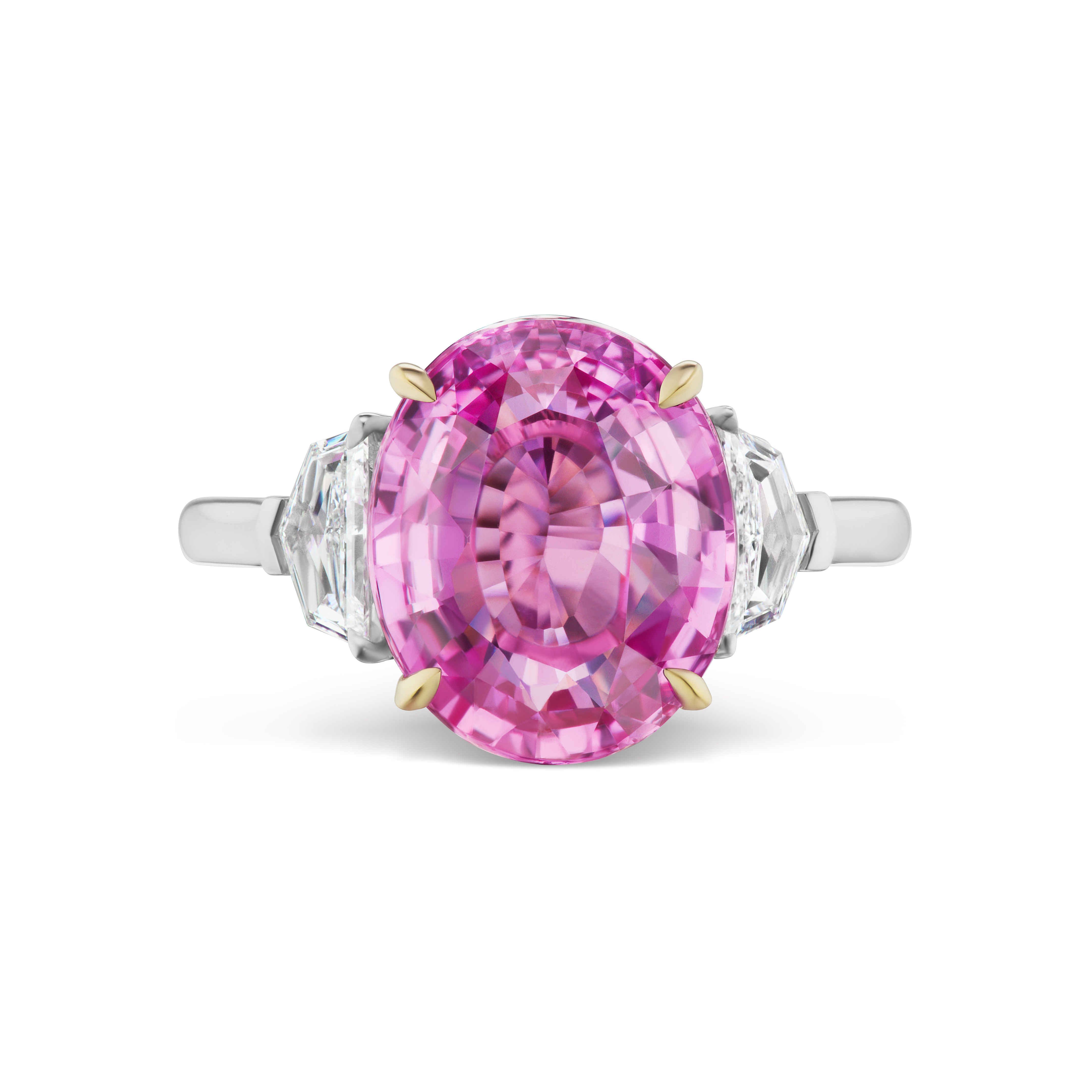 The Oval Sapphire Engagement Ring features a center oval pink sapphire secured by yellow gold prongs and epaulette diamond side stones on an 18K white gold band, creating a striking two-tone effect.