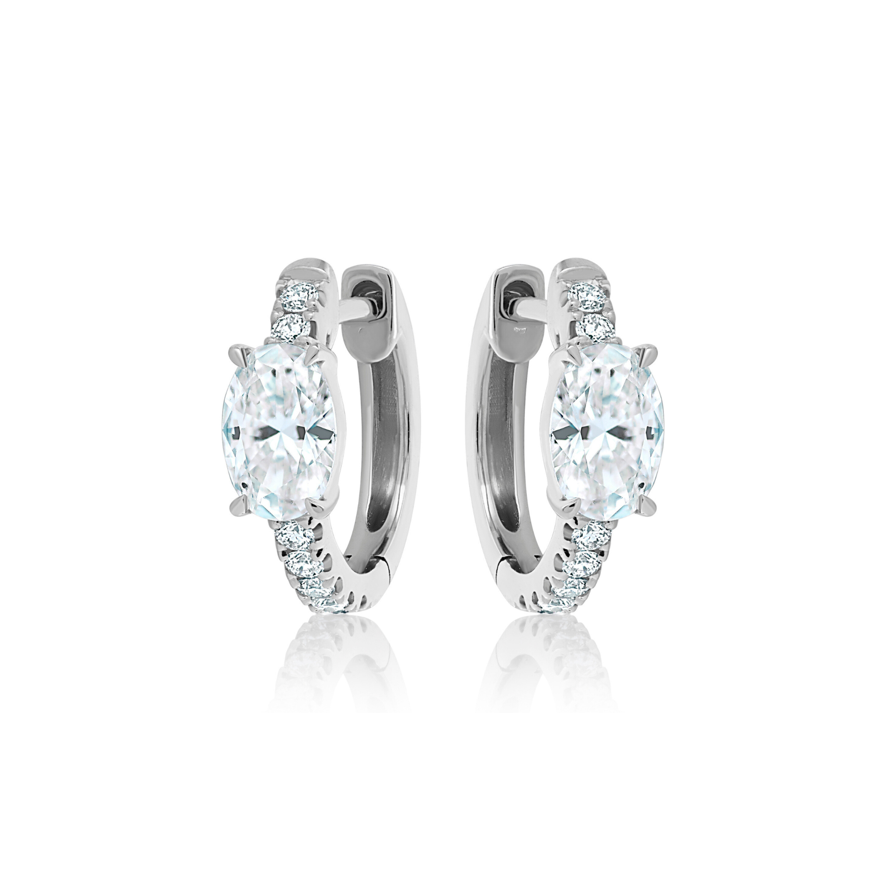 Pavé Huggies with Oval Shape Diamond in White Gold, featuring a center oval diamond and round stones on the front half of each hoop, displayed on a white background.