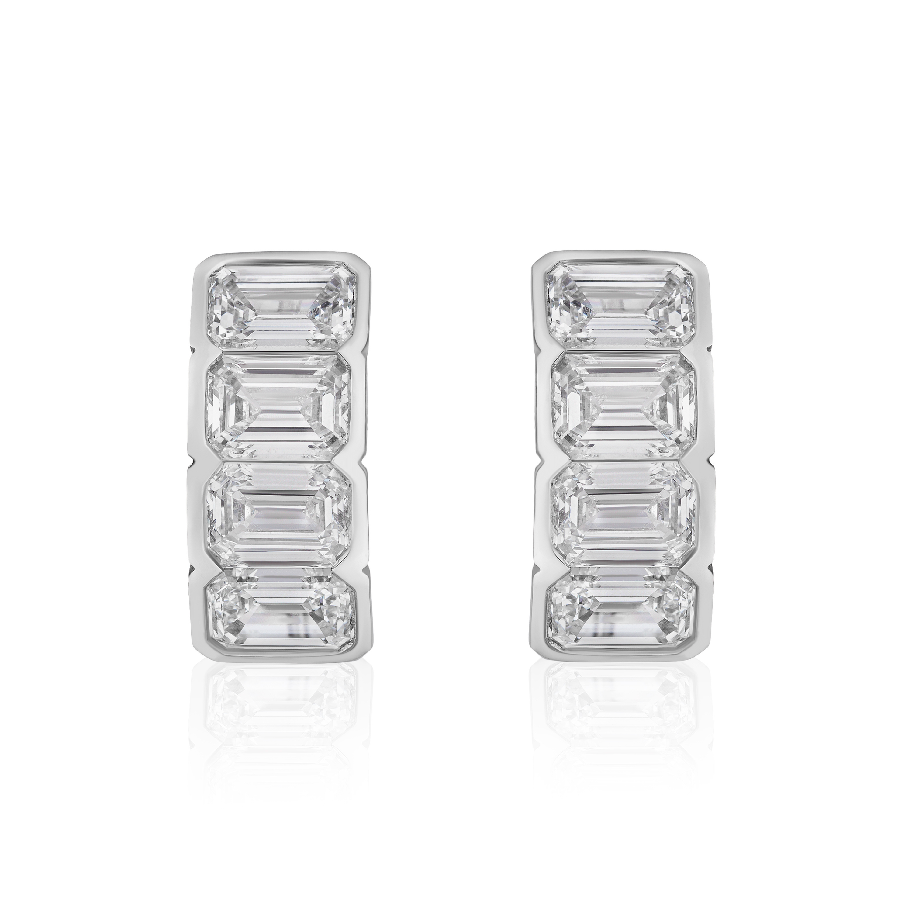 A pair of J Hoop earrings in 18K white gold, each showcasing five vertically stacked bracket bezel set emerald-cut diamonds, displayed on a white background.