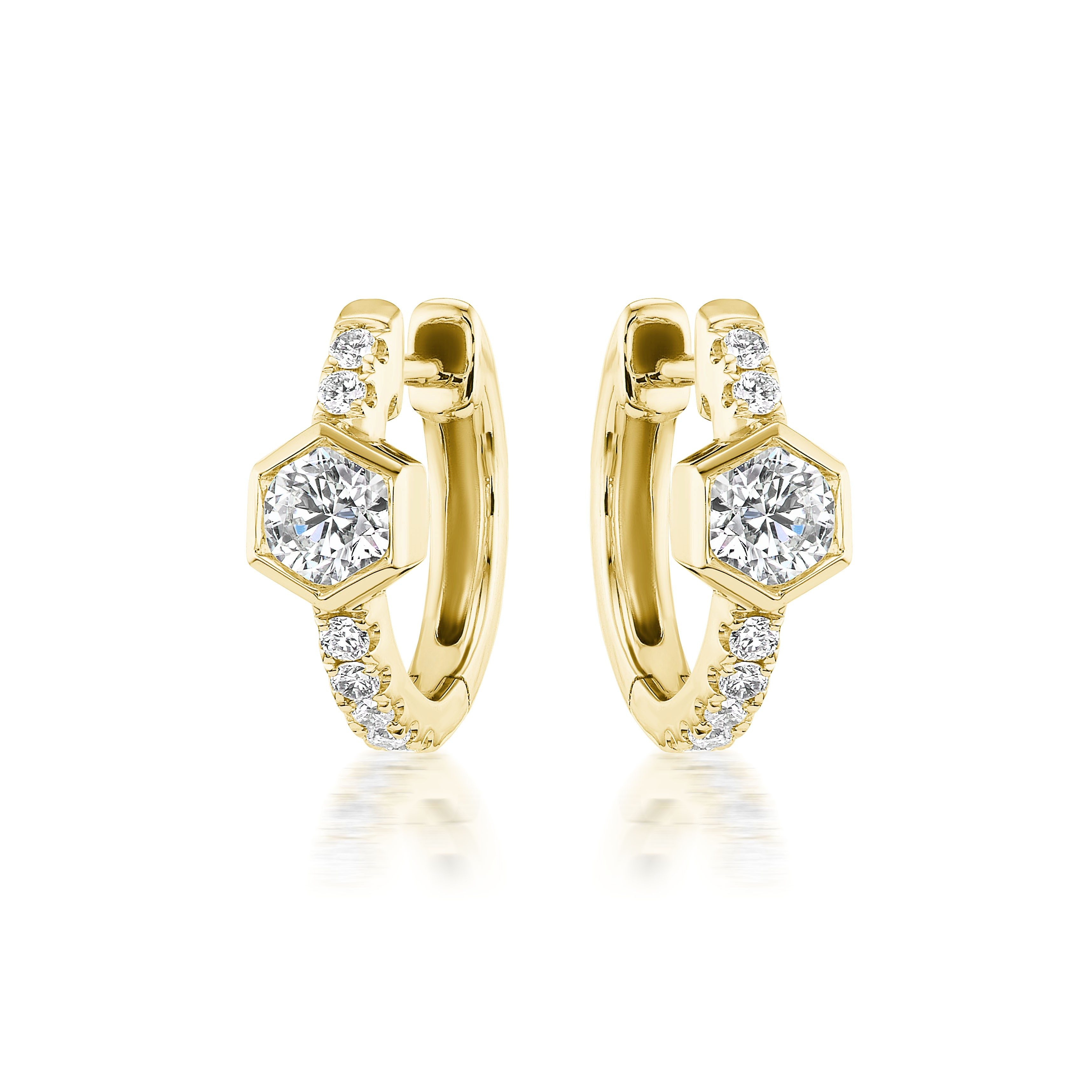 The Pavé Huggies with Hexagon Bezel Set Diamonds are 18K gold hoops featuring central round diamonds in hexagon settings and pavé diamond accents along the front, shown on a white background.