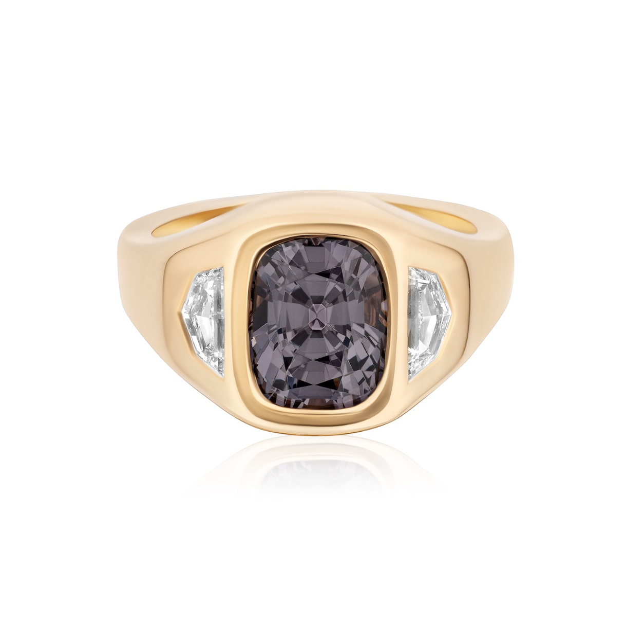 The Bespoke Cushion Cut Spinel Signet Ring in yellow gold, featuring a dark purple spinel and epaulette diamond side stones, is displayed against a white background.