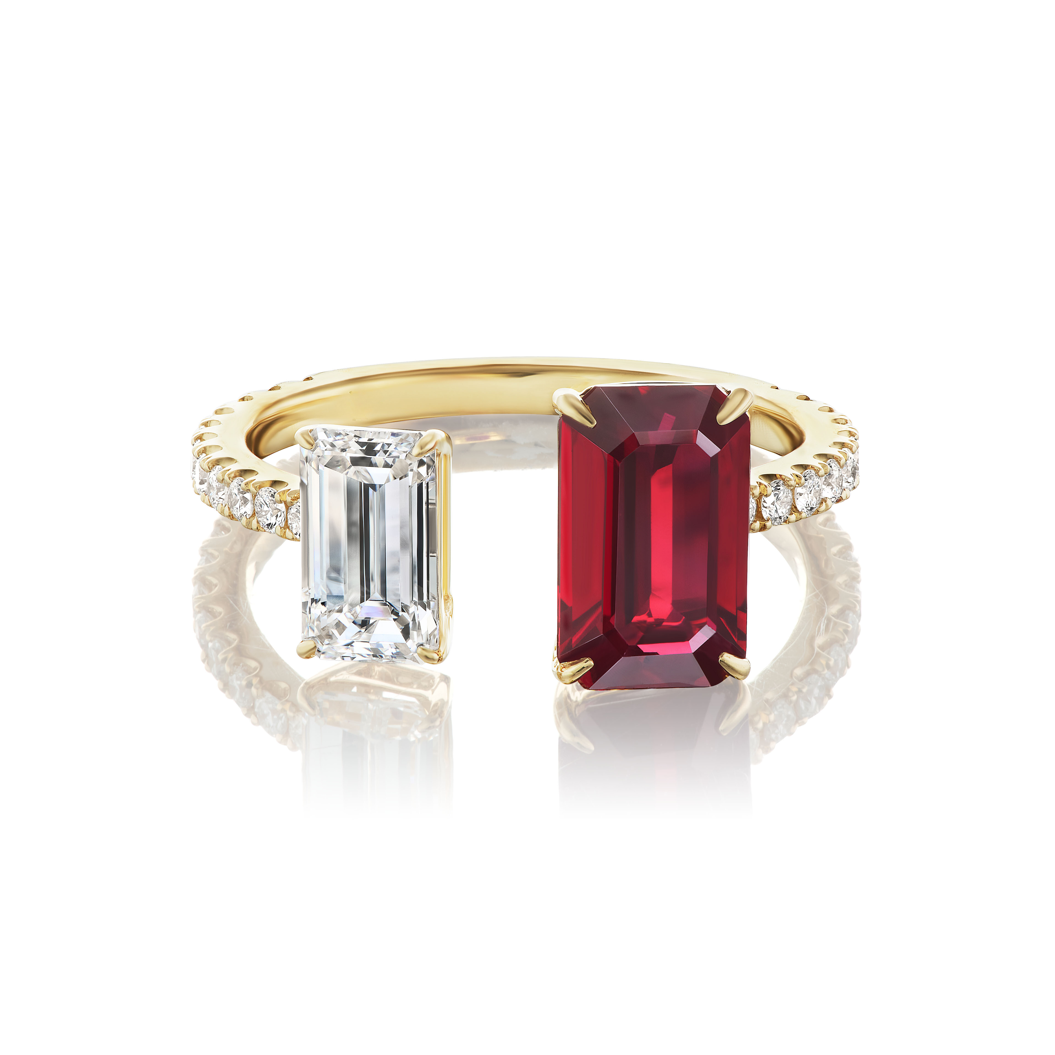 The Toi et Moi Pavé Ring features an emerald cut diamond and a large emerald cut ruby side by side, with ruby diamond pavé on half of the 18K yellow gold band, shown on a white background.