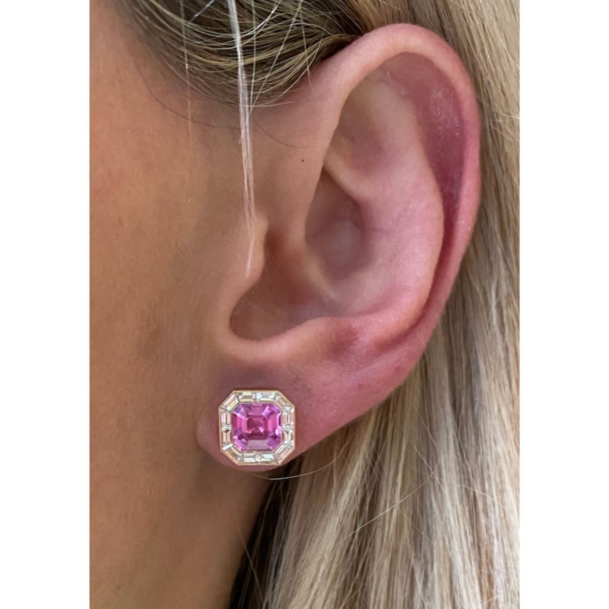 A close-up of a light-skinned, blonde person wearing Mosaic Studs in rose gold, featuring pink asscher cut sapphires surrounded by baguette diamonds.