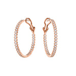 The Bezel Set Hexagon Hoops with Round Brilliant Diamonds feature 18K gold hoops adorned with a row of sparkling round diamonds, displayed on a white background.