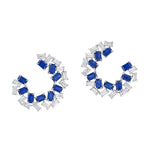 The Chroma Empire Alternating Sapphire and Diamond Front-to-Back Earrings showcase a spiral design with rectangular blue sapphires and clear baguette-cut diamonds set in 18K white gold.