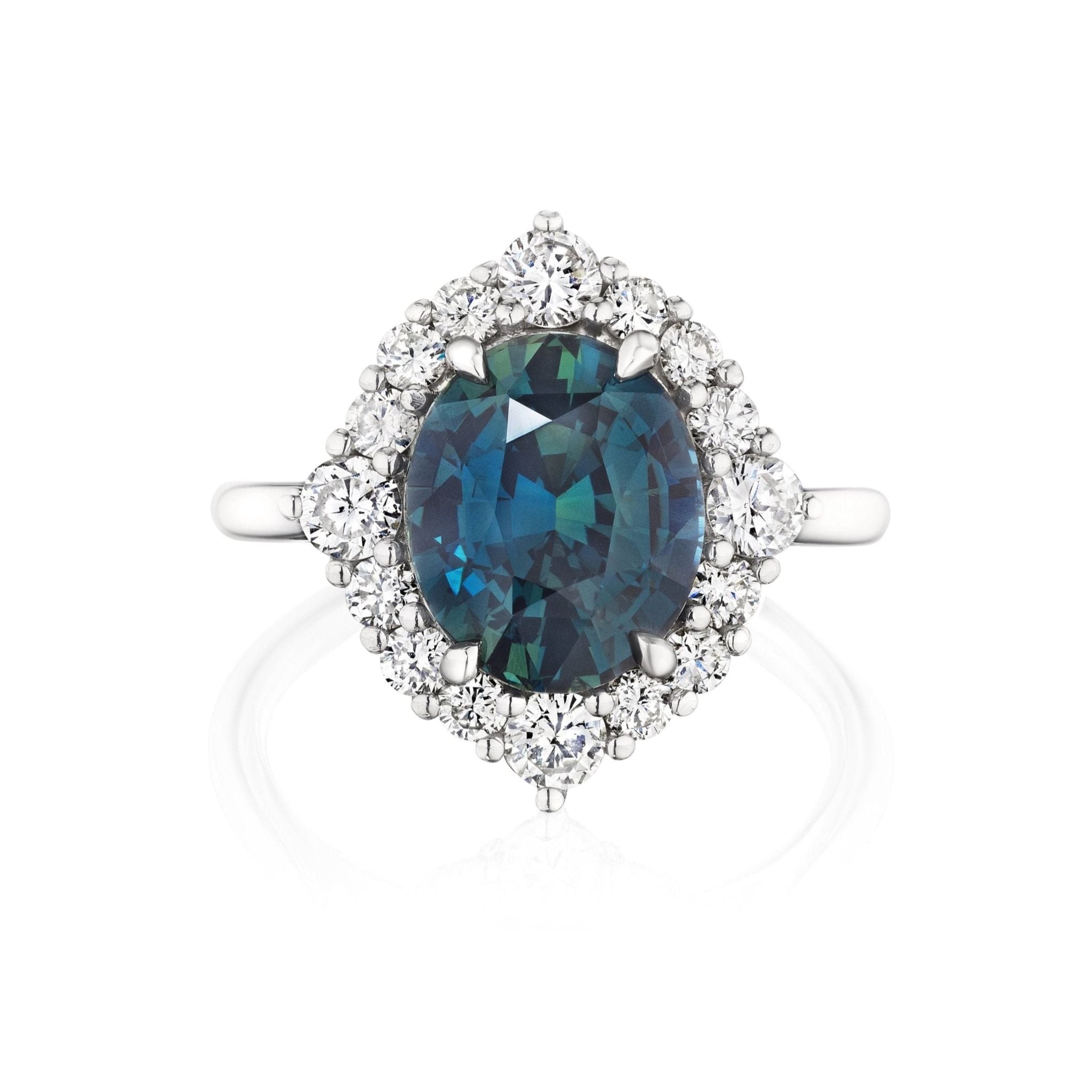 The Teal Oval Sapphire Engagement Ring with Diamond Halo features a stunning teal oval sapphire at the center, framed by sparkling diamonds in elegant 18K white gold.
