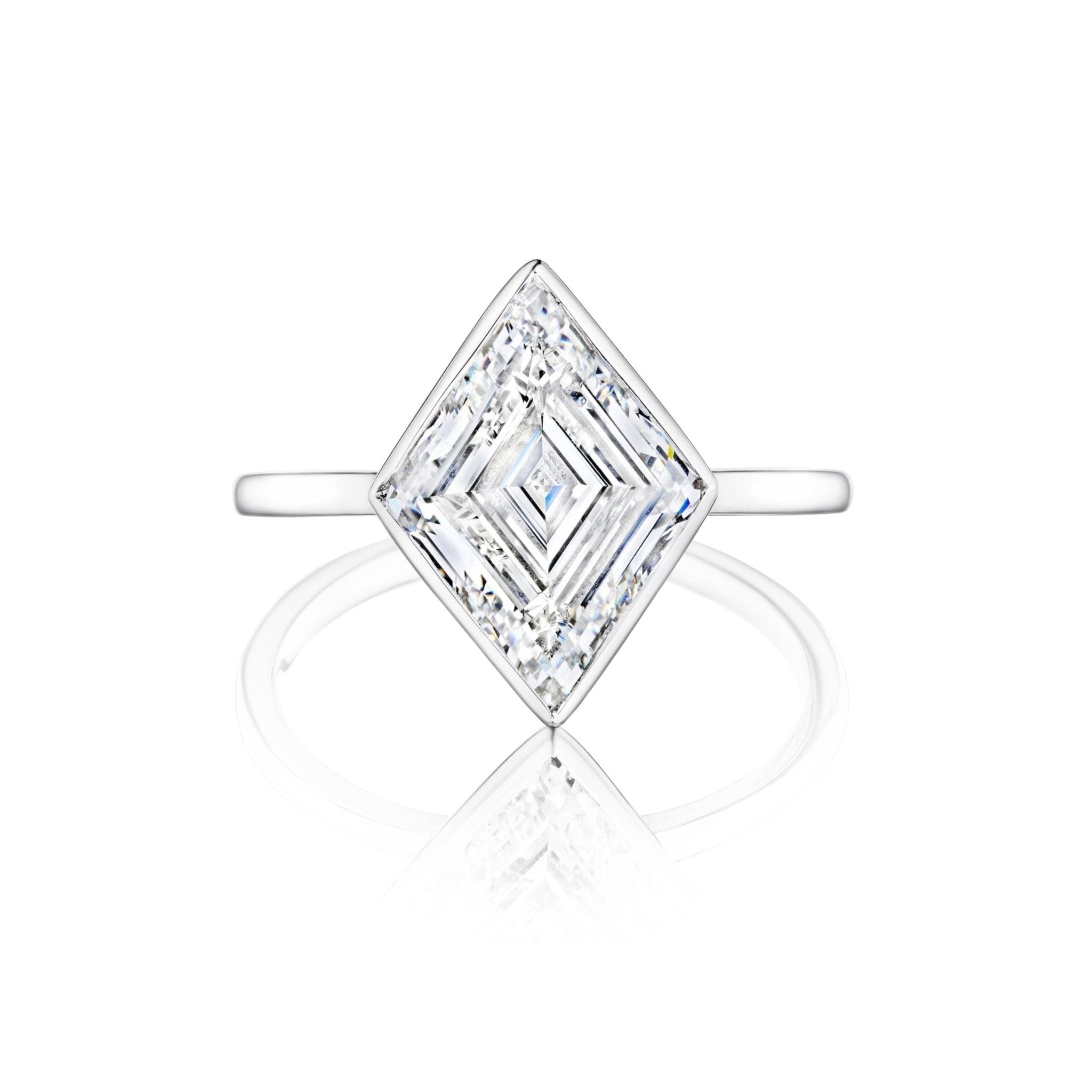 The Bezel Set Lozenge Diamond Engagement Ring showcases a square-cut diamond set diagonally in 18K white gold with a slim band, elegantly presented on a white background.