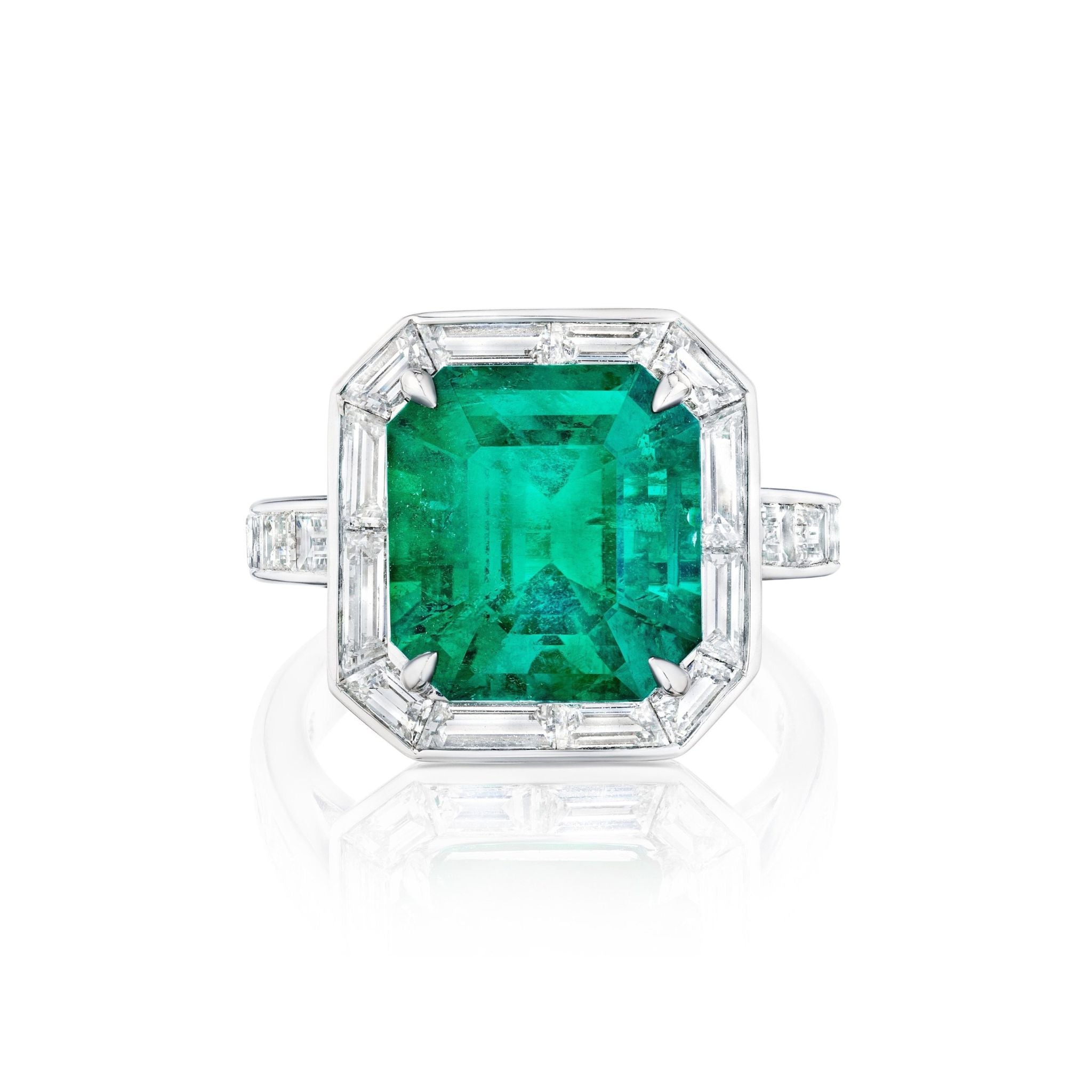 The Mosaic Asscher Cut Emerald and Baguette Diamond Cocktail Ring in Platinum showcases a striking emerald centerpiece, surrounded by baguette diamonds and additional diamonds set along the band.