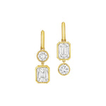 Asymmetrical Drop Earrings with bezel set round and emerald cut diamonds in 18K yellow gold, shown on a plain white background.
