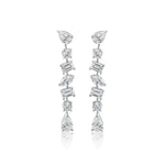 The Tennis Drop Earrings in White Gold with Mixed Shape Diamonds feature round, pear, and rectangular diamonds arranged vertically in an elegant 18K white gold setting.
