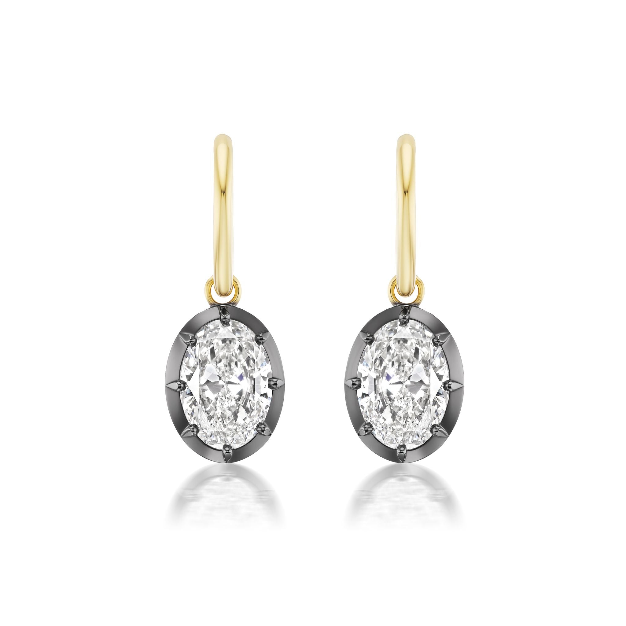 The Collet Set Oval Shape Diamond Drop Earrings feature oval diamonds in yellow gold and black rhodium bezels, hanging from simple gold hooks against a white background.
