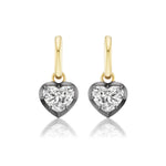 Collet Set Heart Shape Earrings with diamond-like gemstones, set in black rhodium and yellow gold, displayed on a white background.