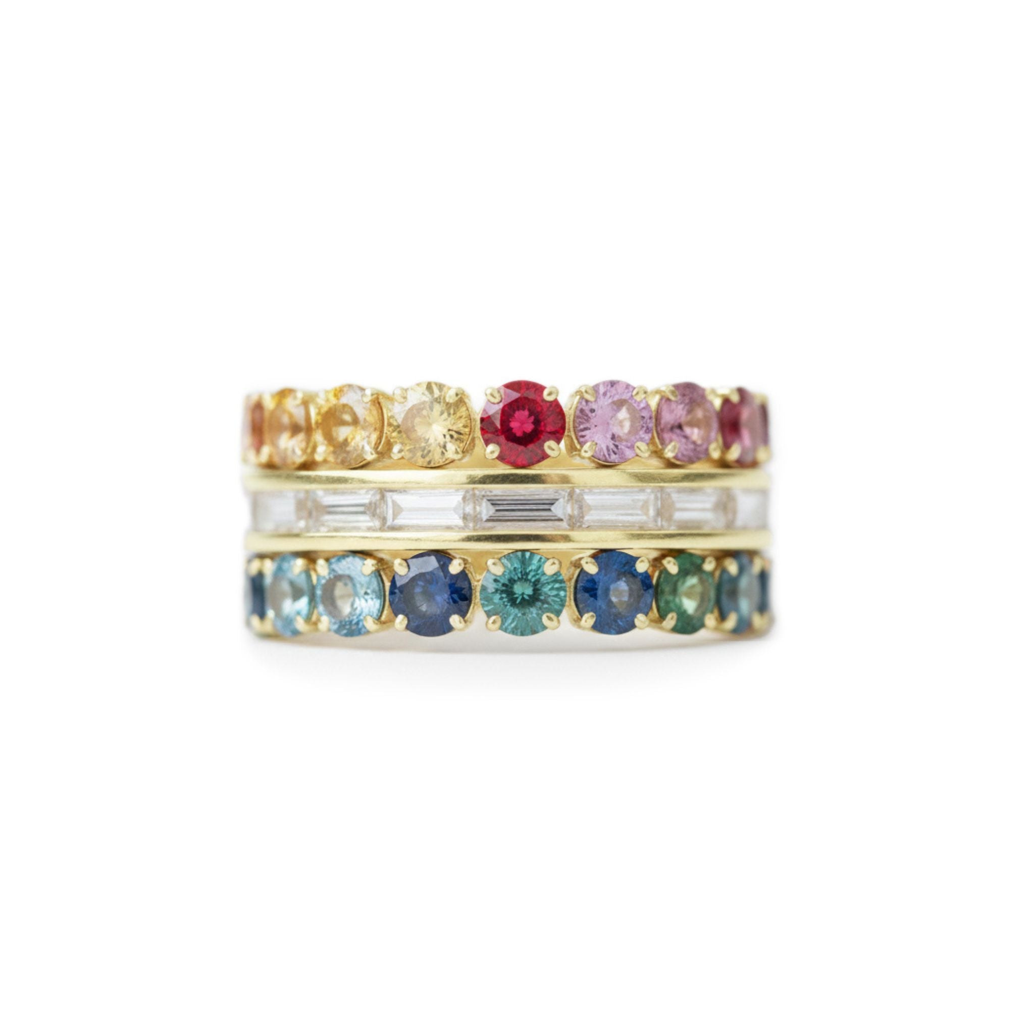 The Channel Set Baguette Diamond Engagement Ring features multicolor round sapphires on top, rectangular diamonds in the center, and round blue-green gemstones at the base—all set in yellow gold against a white background.