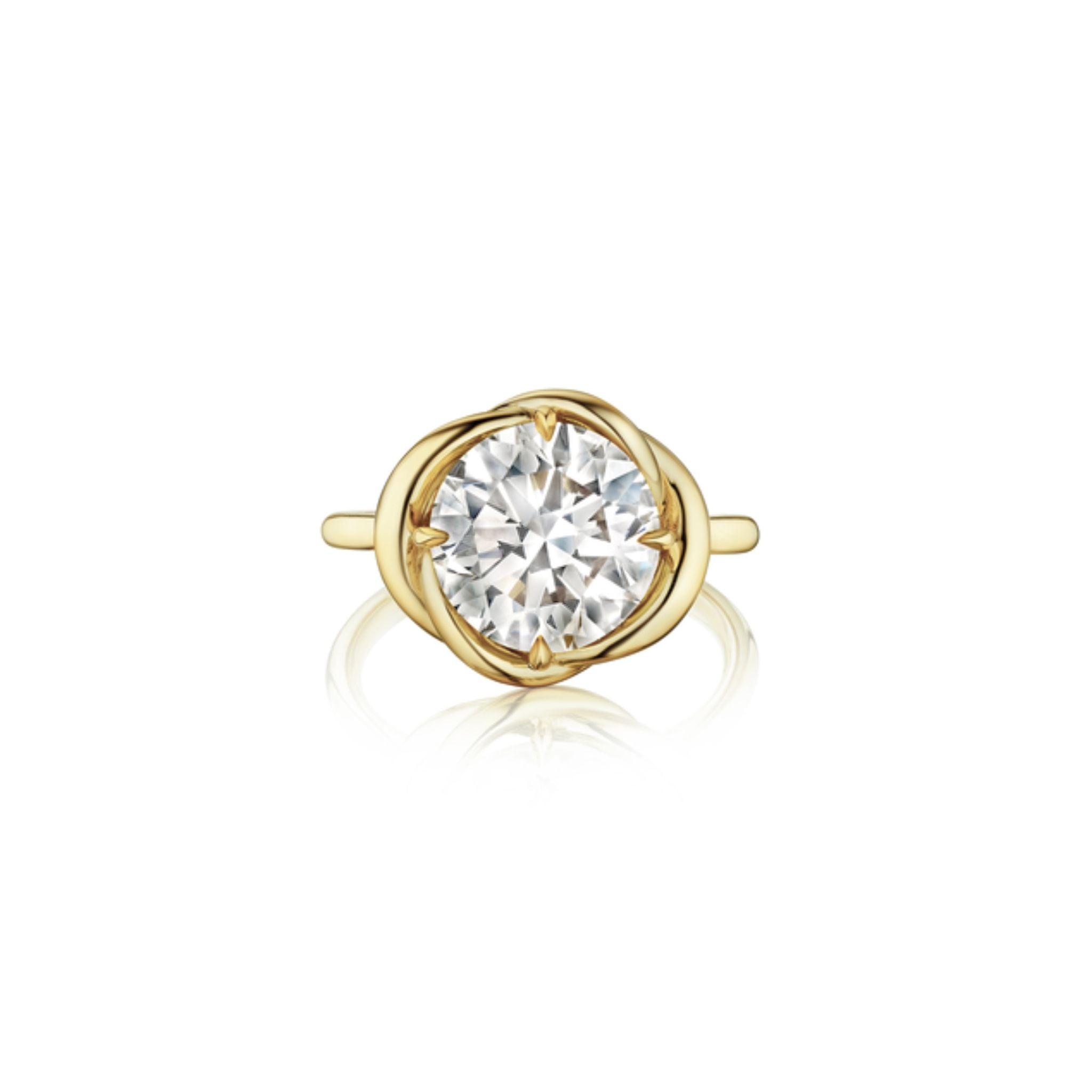 The Round Brilliant Diamond Engagement Ring features a large center diamond set in intertwining yellow gold with a simple gold band.