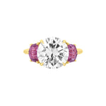 A Round Brilliant Diamond Engagement Ring featuring a central diamond and accented by epaulette pink sapphire side stones.
