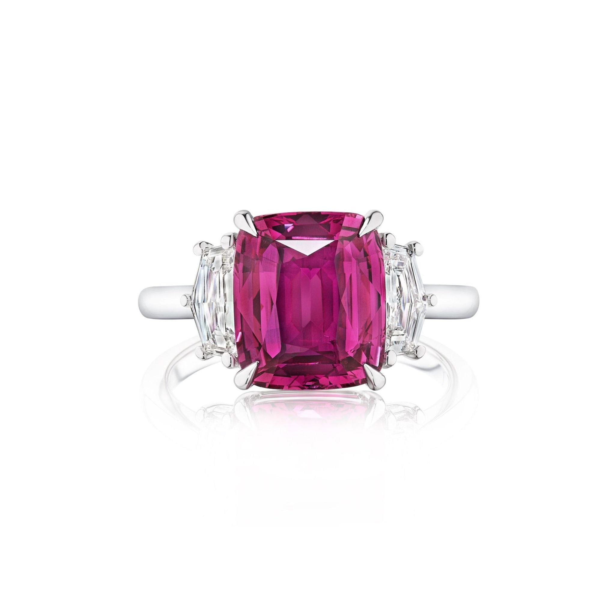 A white gold engagement ring showcasing a cushion-cut pink sapphire at the center, accented by cadillac diamond side stones.