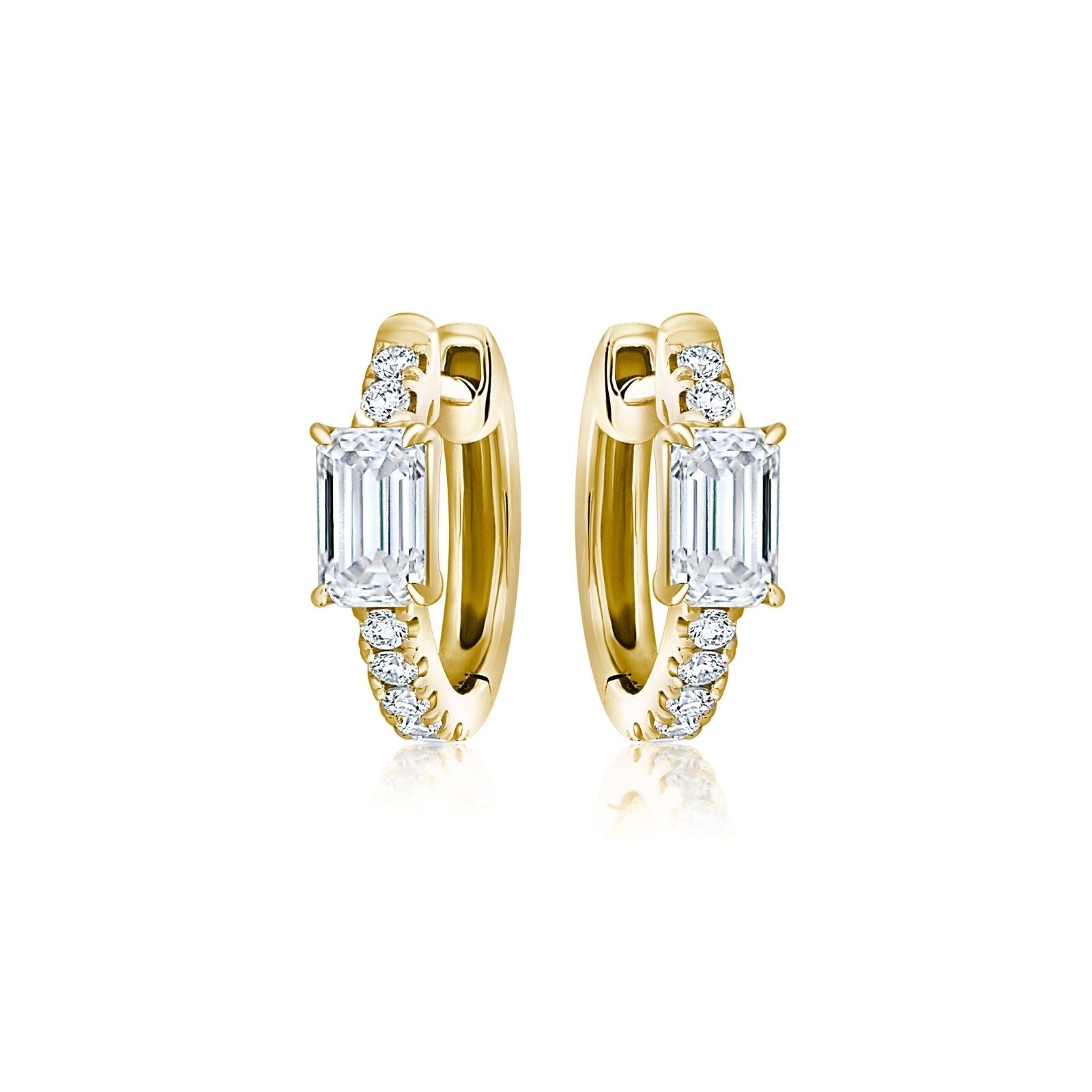 The Pavé Huggie with Emerald Cut Diamonds features 18k gold, small round pavé diamonds, and a larger rectangular emerald-cut diamond on each earring, shown on a white background.