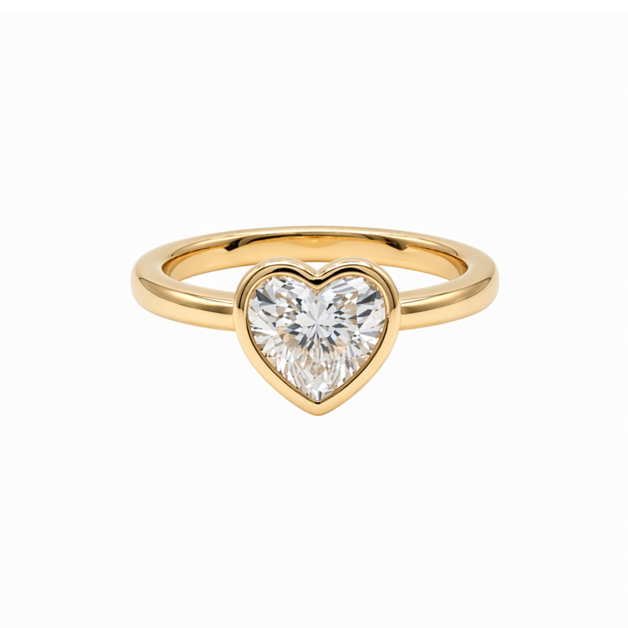 The Bezel Set Heart Shape Diamond Engagement Ring in Yellow Gold features a clear heart-shaped diamond at its center, showcased against a plain white background.