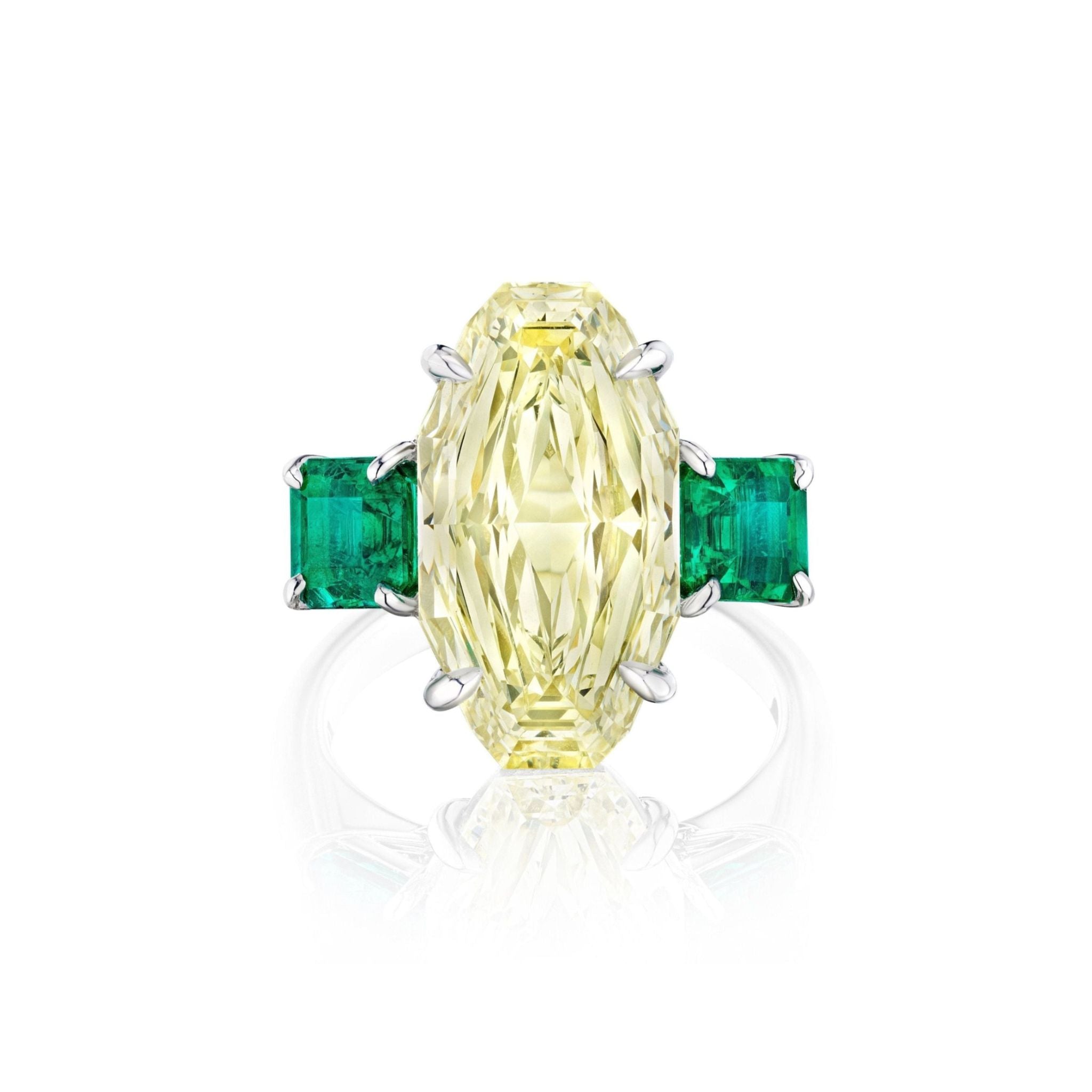 This dazzling Step Cut Oval Yellow Diamond Engagement Ring features a large oval yellow diamond at the center, flanked by square emerald side stones, all set in an elegant 18K white gold band.