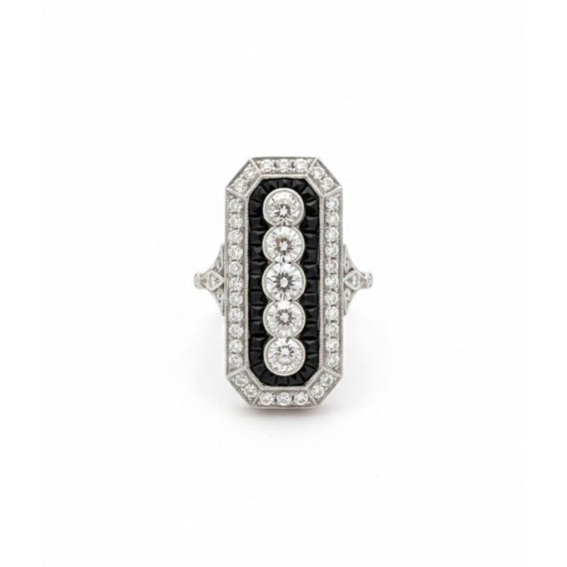 The Onyx and Diamond Ring features five old mine-cut diamonds set vertically, framed by smaller diamonds and calibré-cut onyx accents on a white metal band for a striking vintage-inspired look.