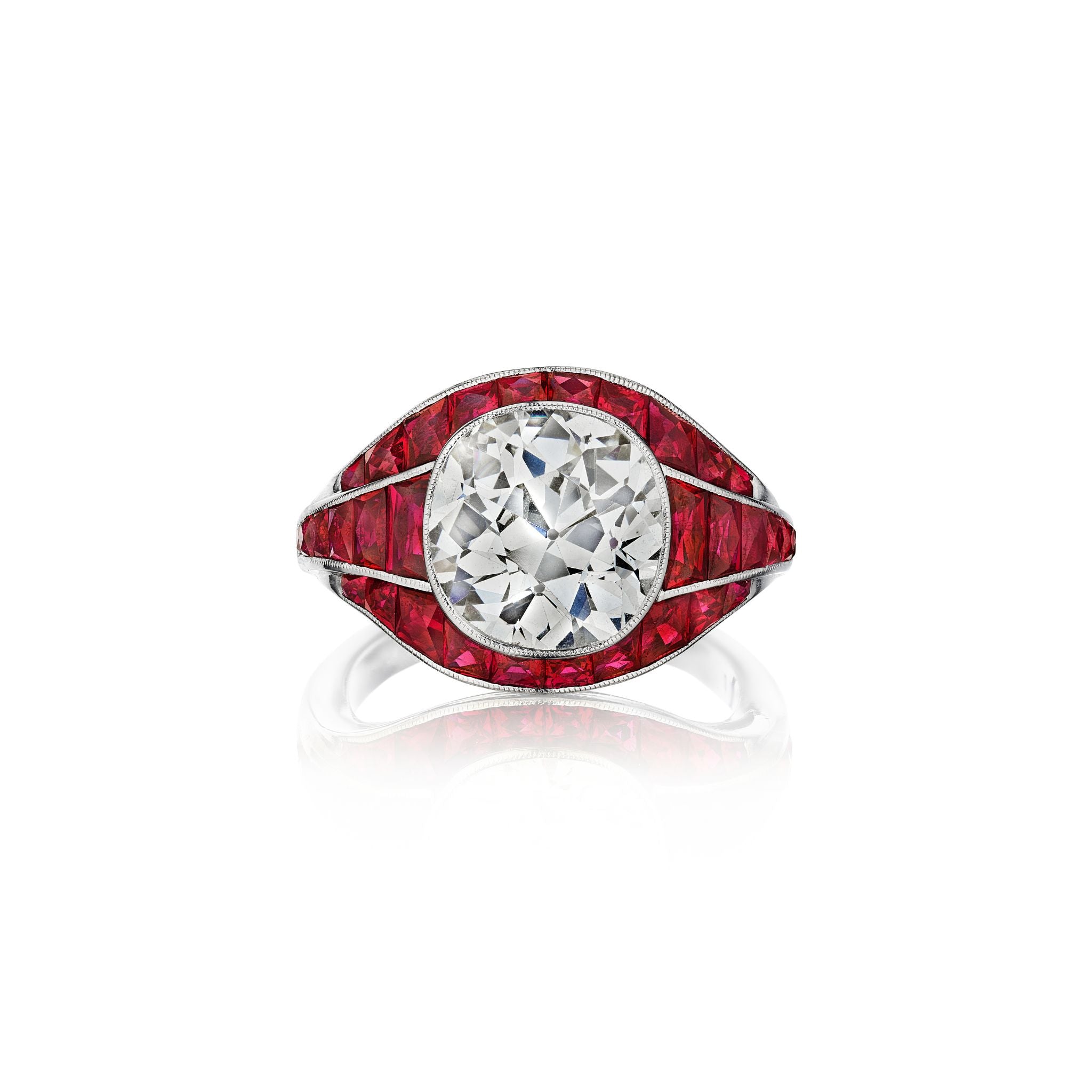 The Bespoke Red Sapphire Ring features a round diamond center stone, accented by geometric square red sapphires and set in a sleek white gold band.