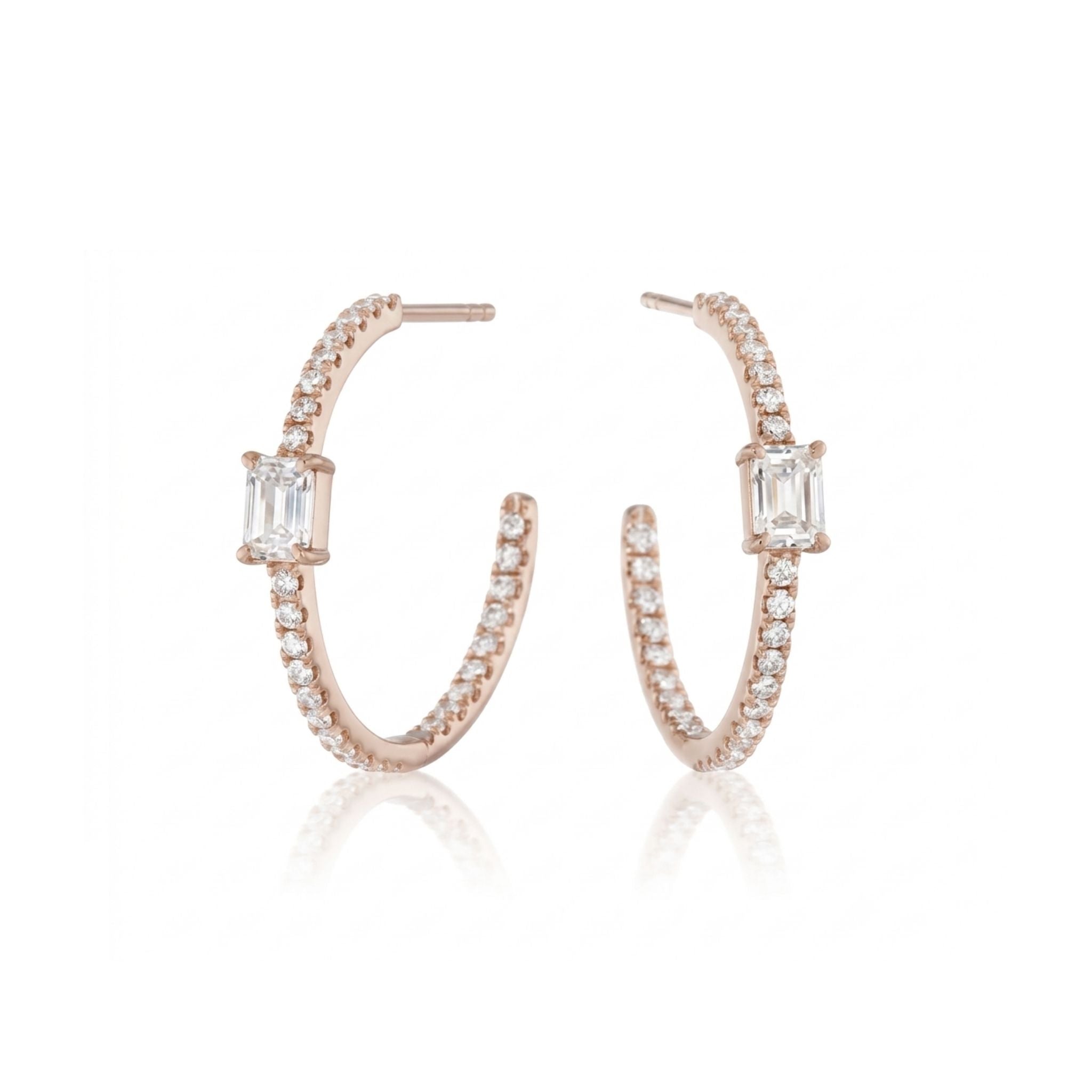 A pair of Pavé Hoops with Emerald Cut Diamonds in Yellow Gold, each adorned with small white gemstones and a central emerald cut diamond, displayed on a white background.