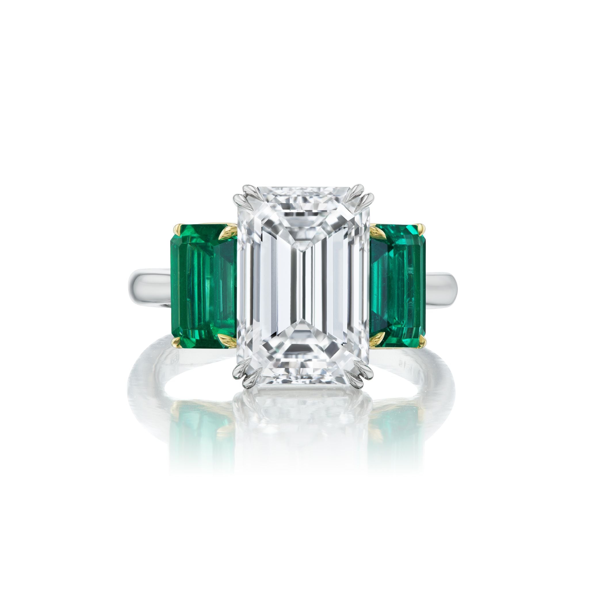 Emerald Cut Diamond Engagement Ring with Emerald Cut Emerald Side Stones, crafted in platinum and featuring a prominent emerald cut diamond center stone accented by two emerald cut emerald stones on a sleek band.