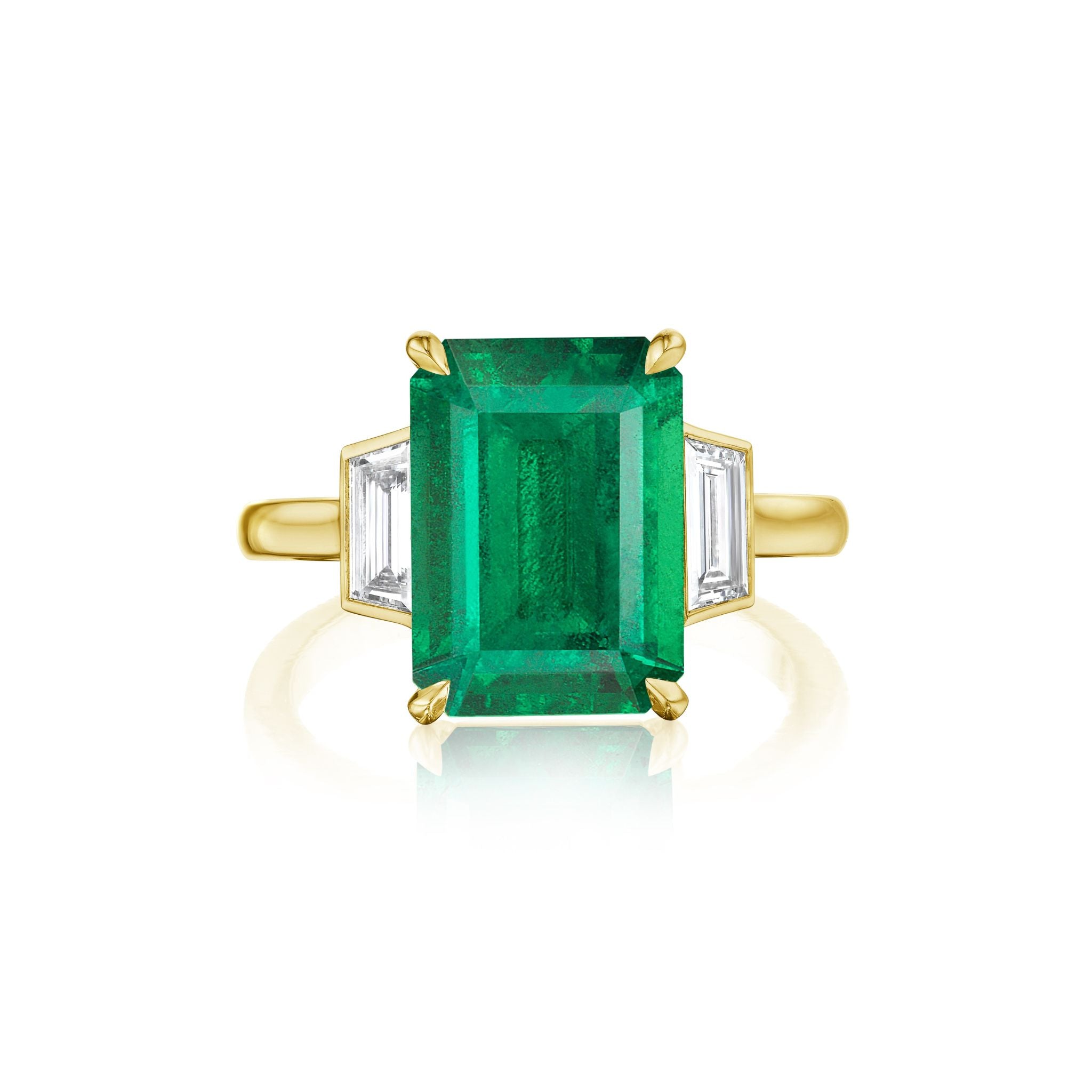 An elegant 18k yellow gold engagement ring, the Emerald Cut Emerald Engagement Ring with Bezel Set Diamond Trapezoid Side Stones highlights a striking emerald cut emerald as its center stone, accented by bezel set diamond trapezoid side stones for a distinctive and sophisticated look.