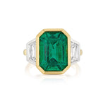 Introducing the Bezel Set Emerald Cut Emerald Engagement Ring in Yellow Gold and Platinum with Trapezoid Baguette Diamond Side Stones: This exquisite ring features a prominent emerald cut green emerald at its center, beautifully bezel set in a blend of yellow gold and platinum. Flanked by sparkling trapezoid baguette diamond side stones, the elegant dual-metal setting highlights the unique interplay between precious metals and gemstones, making this an enchanting choice for an engagement ring.