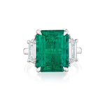This exquisite Emerald Cut Colombian Emerald Engagement Ring in white gold showcases a captivating central emerald, accented by elegant trapezoid baguette side stones.