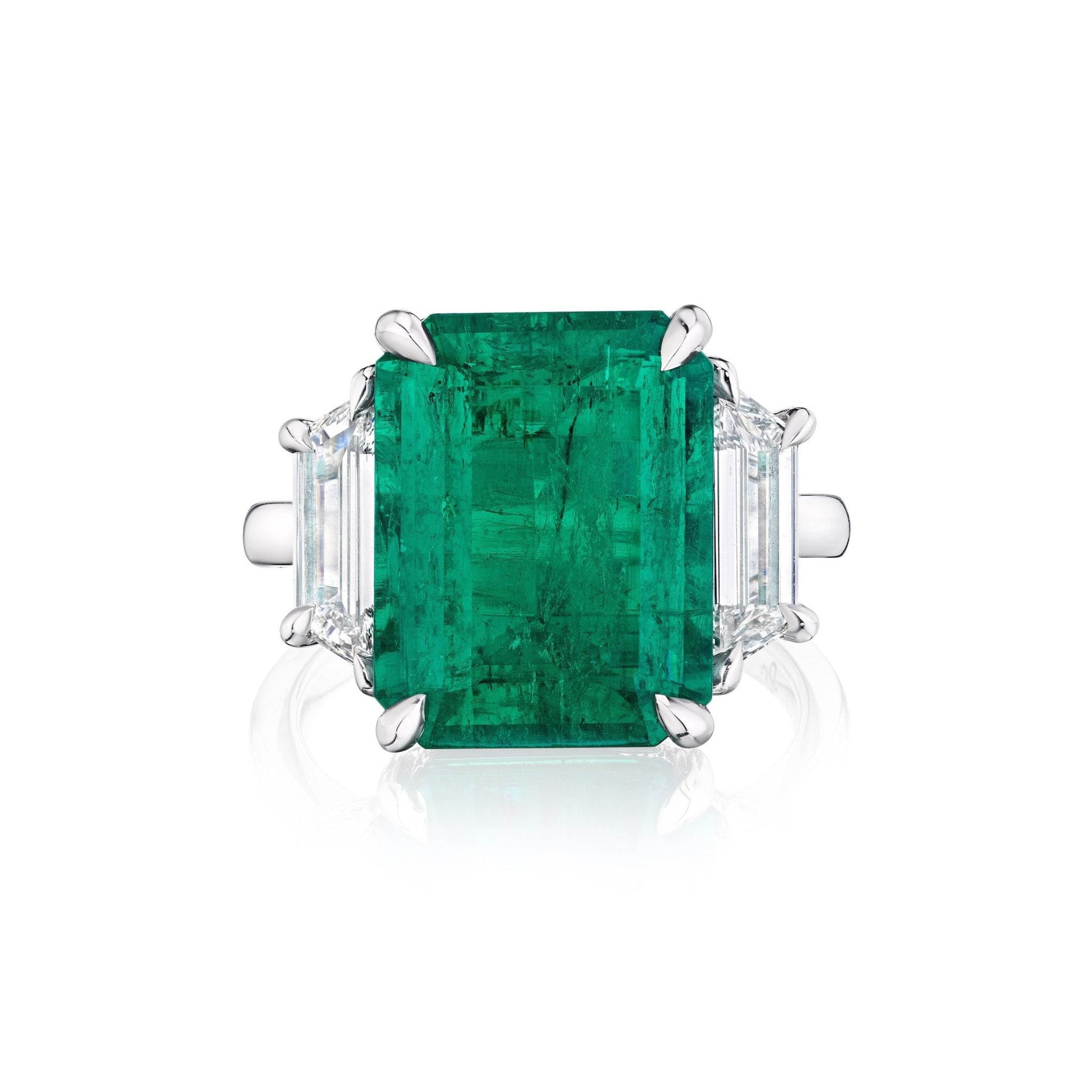 This exquisite Emerald Cut Colombian Emerald Engagement Ring in white gold showcases a captivating central emerald, accented by elegant trapezoid baguette side stones.