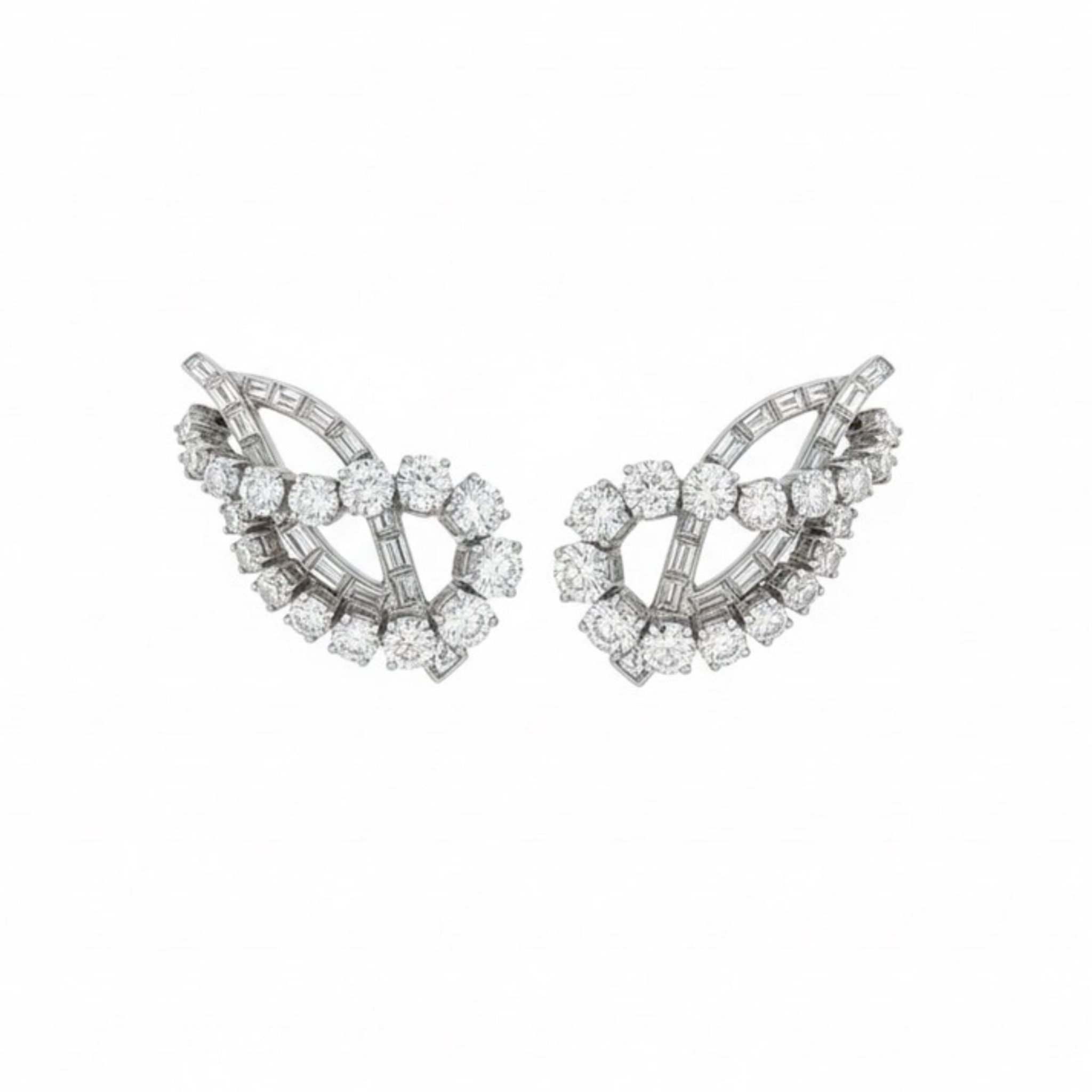 A pair of Diamond Earclips featuring a curved, leaf-inspired design with multiple round and baguette-cut diamonds set in platinum, offering a timeless look inspired by 1950s elegance.