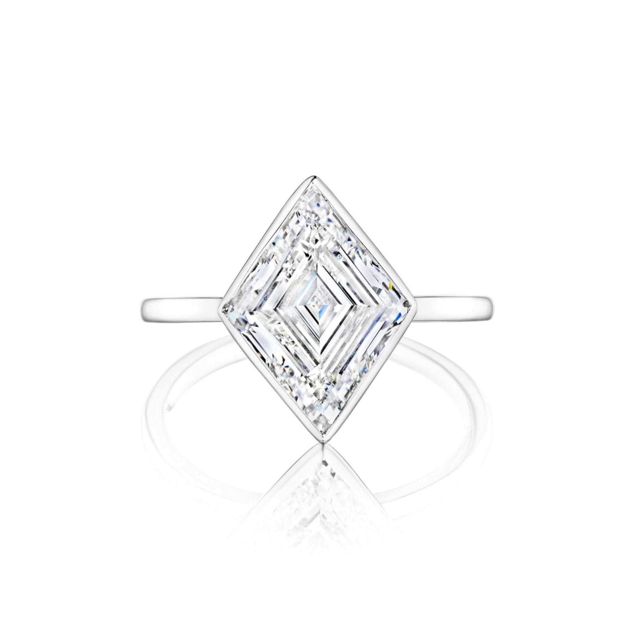 Introducing the Bezel Set Lozenge Diamond Engagement Ring, a stunning 18K white gold piece showcasing a large, square-cut diamond elegantly set in a bezel and oriented in a striking lozenge shape, beautifully displayed against a white background.
