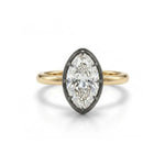 Introducing the Collet Set Marquise Diamond Solitaire Ring in Black Rhodium and Yellow Gold, showcasing a marquise-cut diamond set in a striking black rhodium bezel and elegantly complemented by an 18k yellow gold band, presented against a crisp white background.