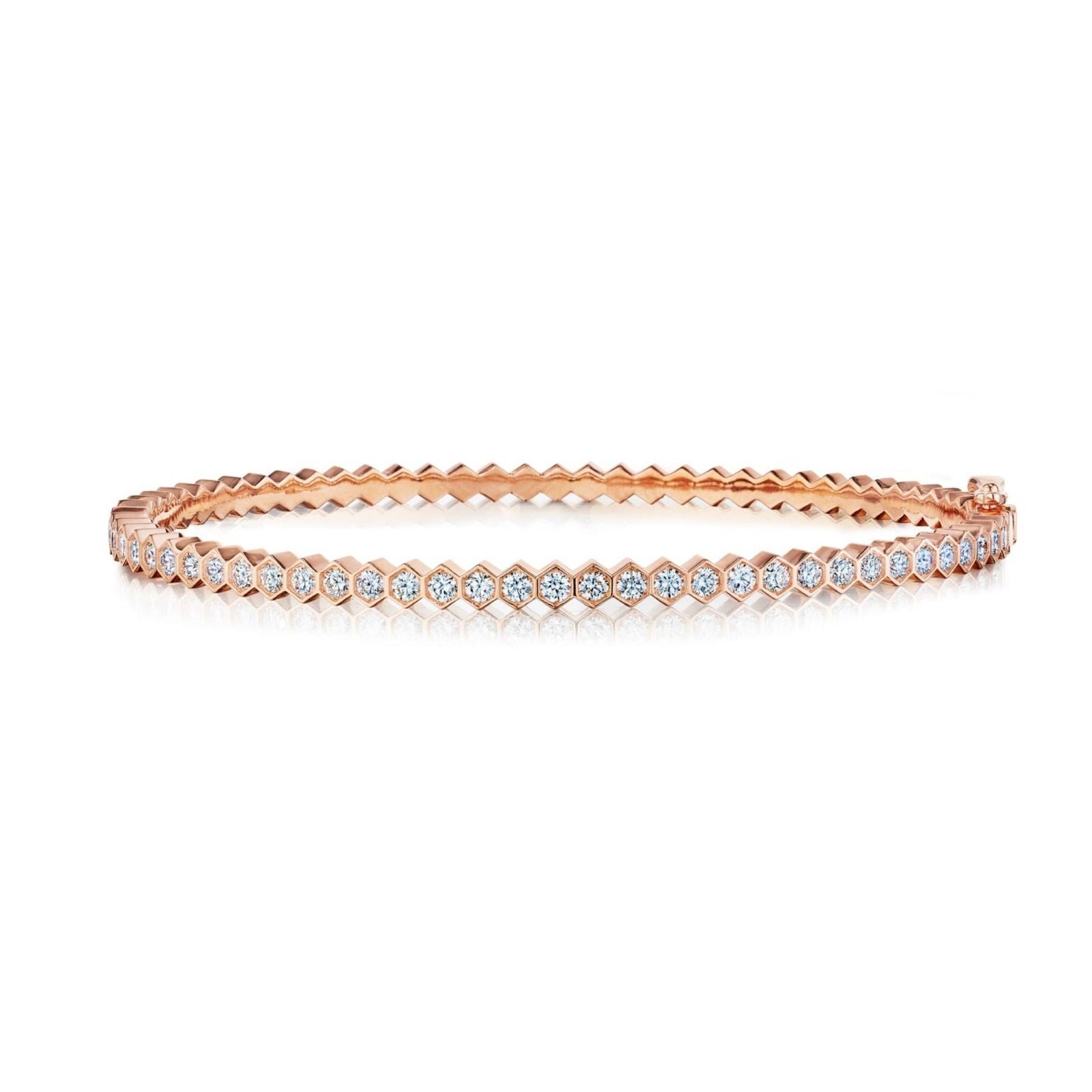 The Hexagon Bezel Set Diamond Bangle is an 18k gold bracelet with a modern hexagonal pattern and sparkling round diamonds set along the top—a refined update to the classic diamond bangle.
