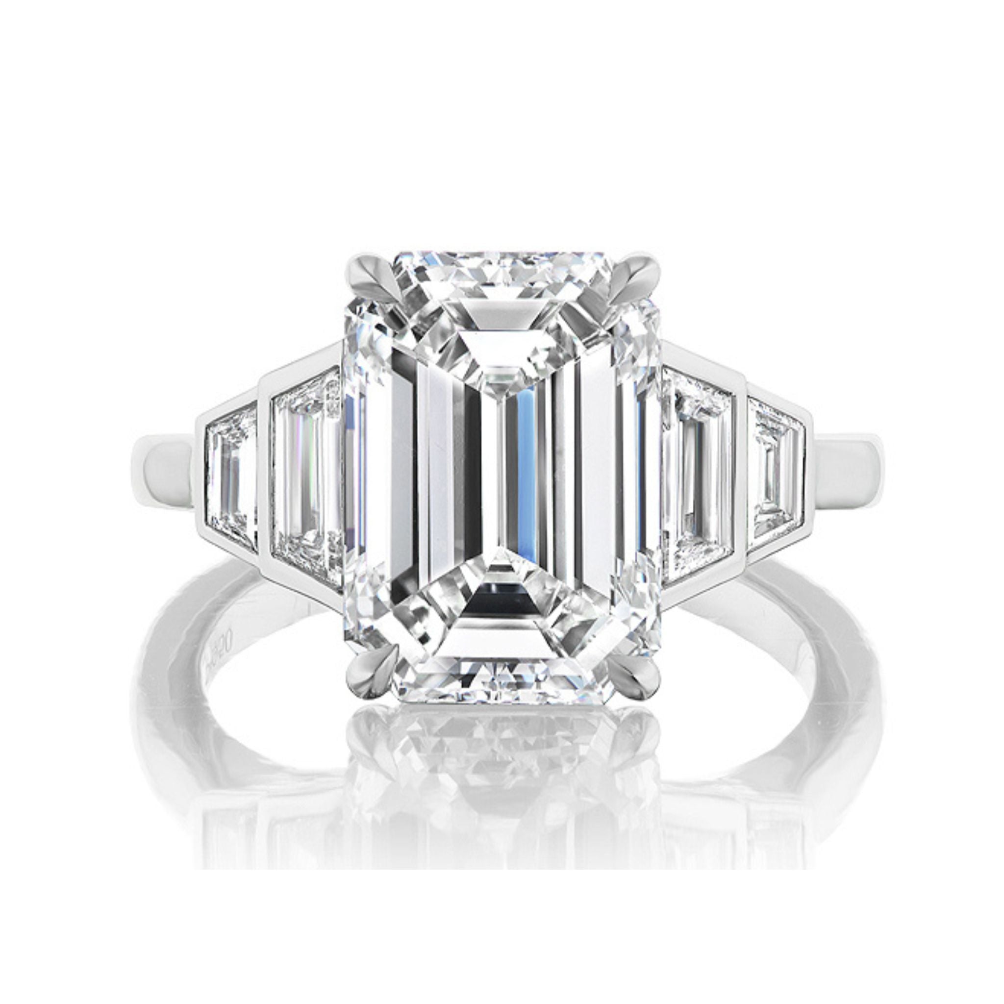 The Echo Emerald Cut Diamond Engagement Ring features a platinum band with a large emerald-cut center diamond and bezel-set graduating trapezoid side stones—an elegant, modern choice for an engagement ring.