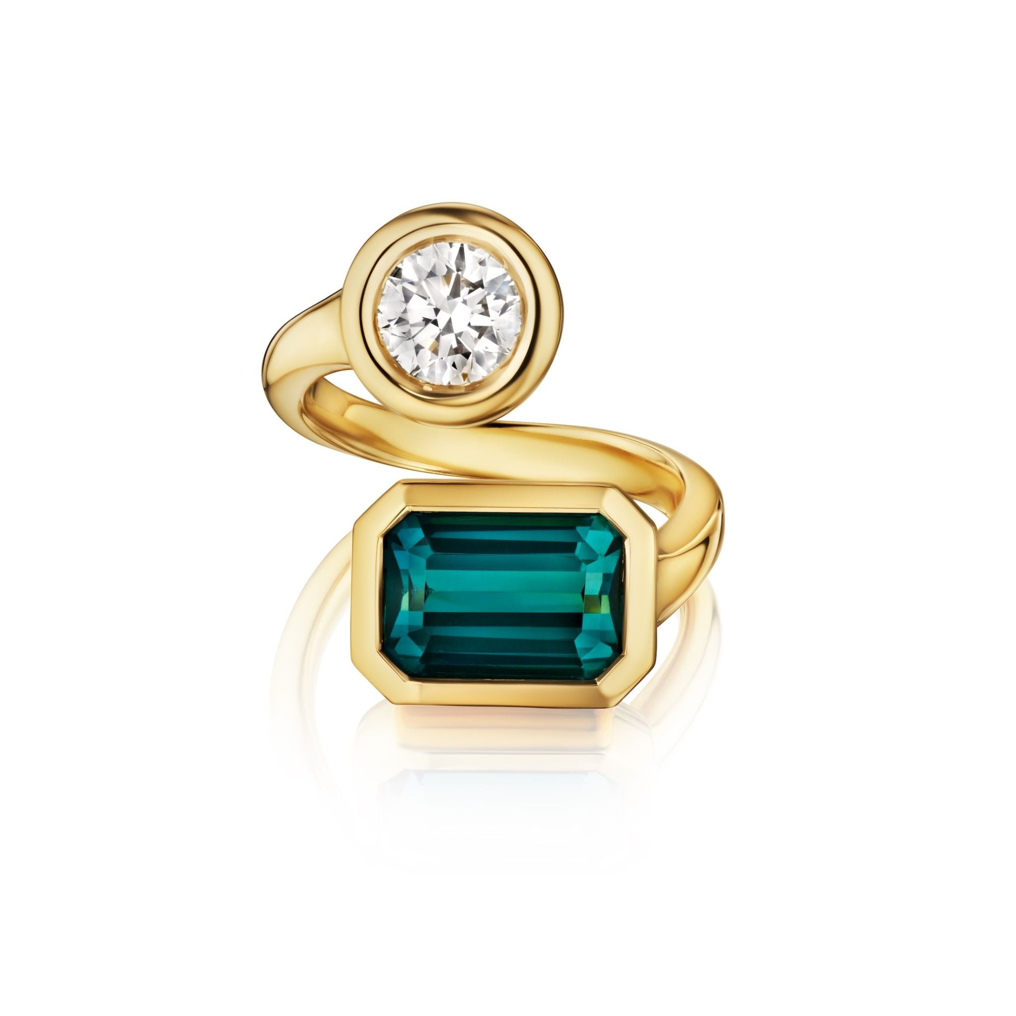 The Bezel Set Toi et Moi Wrap Ring features a round diamond and an emerald cut tourmaline, both set on opposite ends of a twisting yellow gold band, shown against a white background.