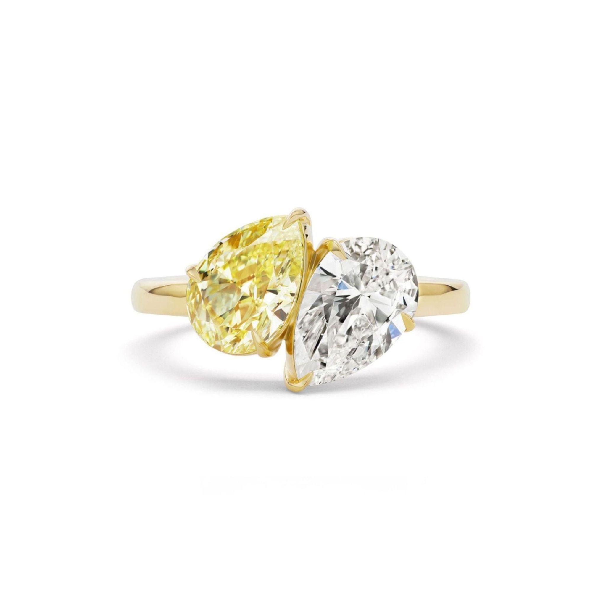 Introducing the Toi et Moi Ring with Fancy Yellow and White Pear Diamonds: a gold celebration ring showcasing two pear-shaped gems—one a vibrant fancy yellow diamond and the other a sparkling white diamond—set side by side with their tips meeting at the center. The minimalist band enhances the striking contrast between the stones, creating an elegant and refined piece of bespoke jewelry.