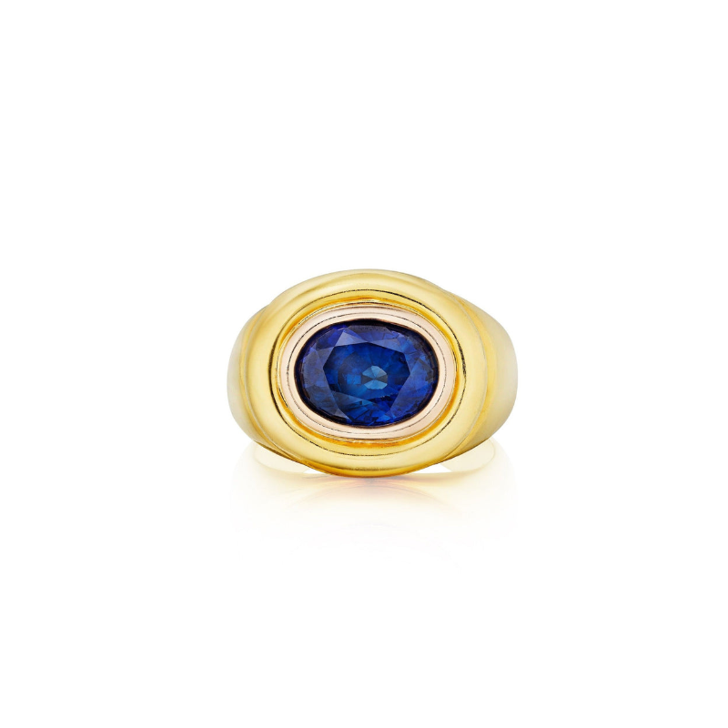 The Gold and Sapphire Ring features a wide gold band with a round, deep blue 3.80 carat sapphire set in the center, shown on a white background.
