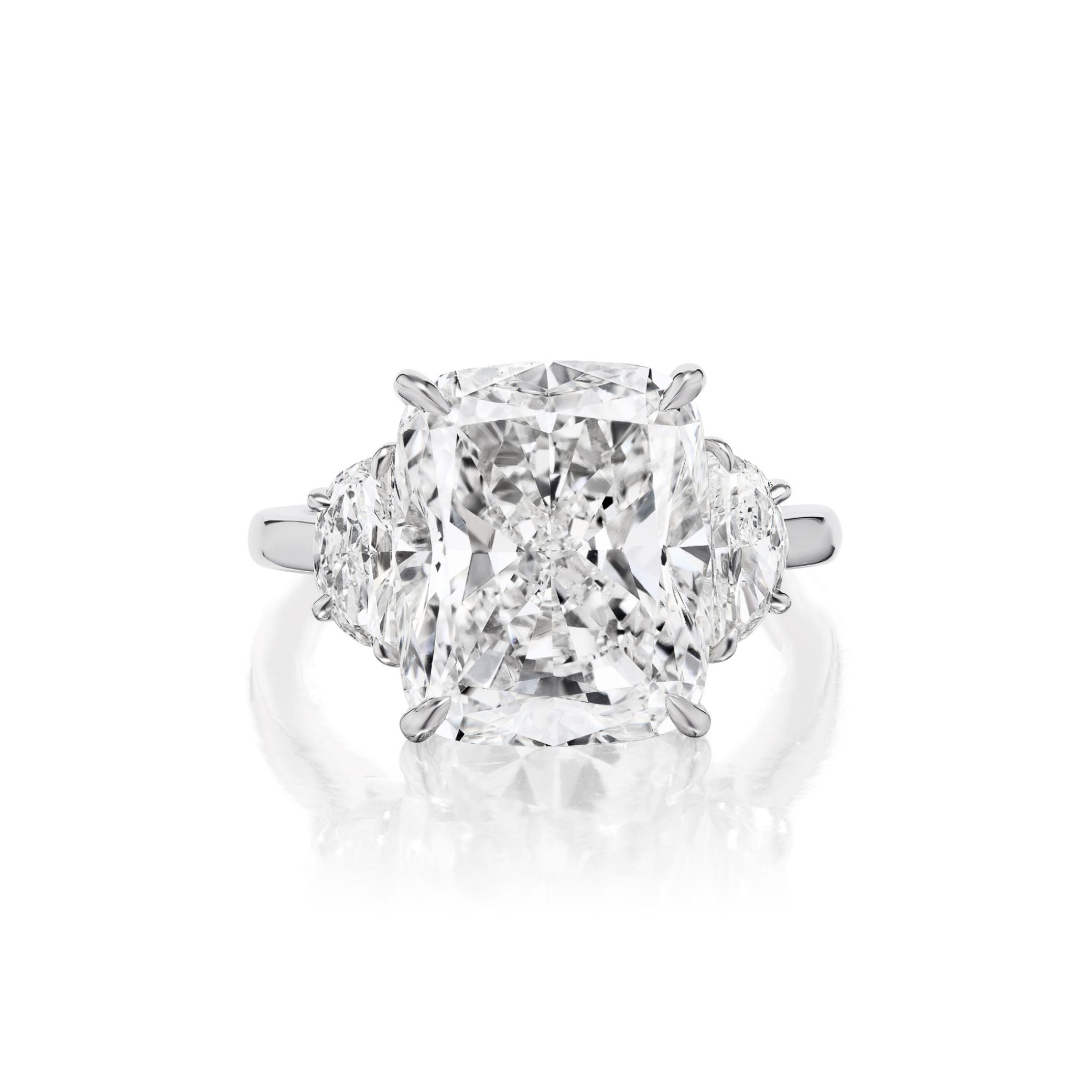 The Cushion Cut Diamond Engagement Ring with Half Moon Side Stones, set on a gleaming white metal band and showcased against a white background, features a cushion-cut center diamond flanked by two half-moon side stones.