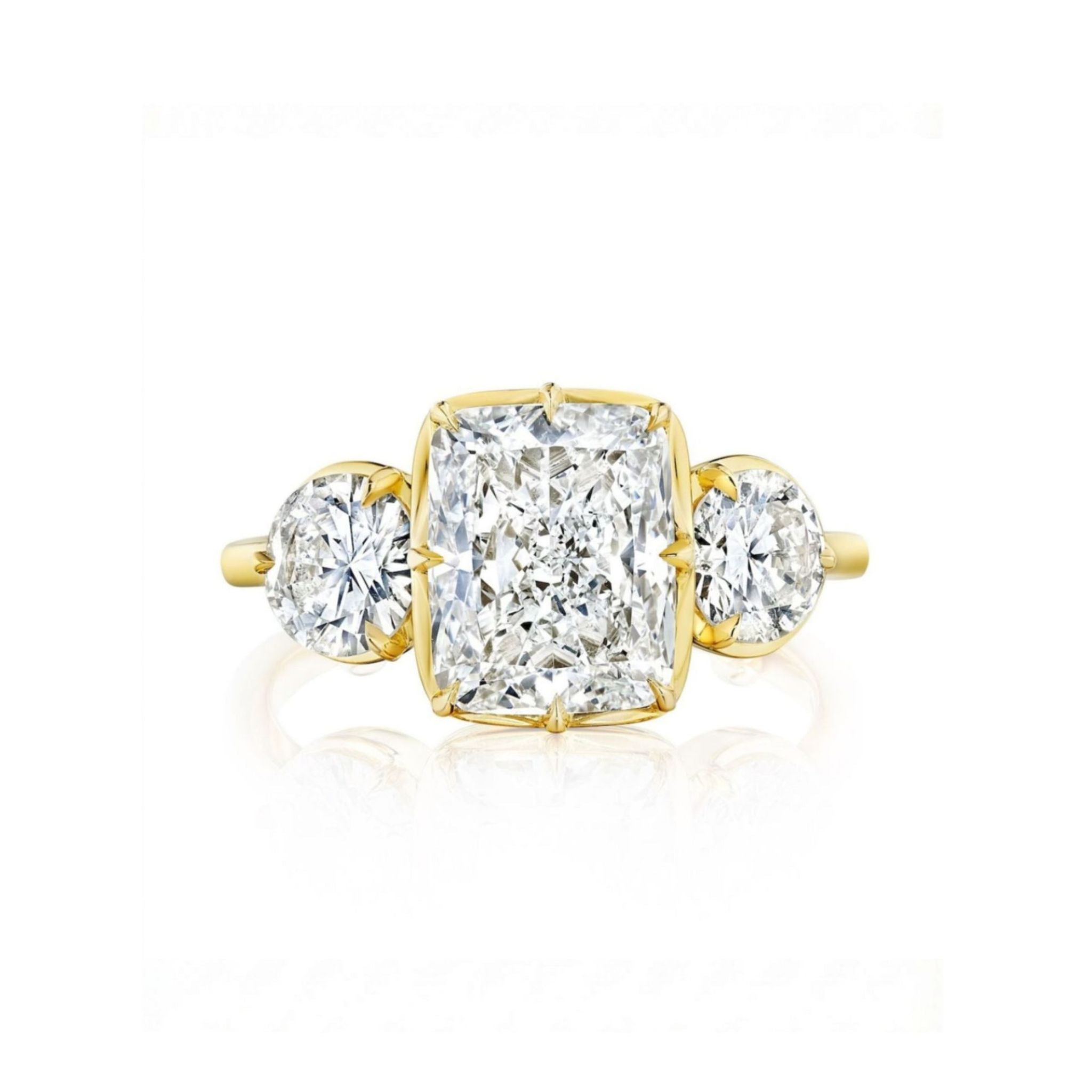 A Collet Set Cushion Cut Diamond Engagement Ring with Round Side Stones in Yellow Gold is displayed against a white background, featuring a cushion-cut diamond at the center set in 18k yellow gold and complemented by round diamond side stones on each side.