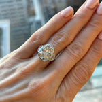 A hand with light pink manicured nails is wearing the Radiant Cut Diamond Engagement Ring, featuring a bezel setting and epaulette side stones, on the ring finger.