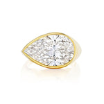 An elegant East-West Bezel Set Pear Shape Diamond Ring in yellow gold, showcasing a striking pear-shaped diamond, displayed against a white background.