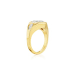This striking Burnish Set Gypsy Ring by Serpentine Jewels is crafted in yellow gold and features a thick band adorned with a prominent center diamond, flanked by two smaller round and pear-shaped diamonds on each side. The ring is elegantly displayed against a white background.