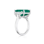 Side view of the Emerald Cut Colombian Emerald Engagement Ring in White Gold with Trapezoid Baguette Side Stones, featuring a large emerald cut Colombian emerald set in prongs and accented by trapezoid baguette side stones, displayed on a white background.